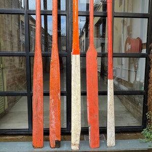 Close up of long, red vintage boat oars 3 - 4 metres long. 