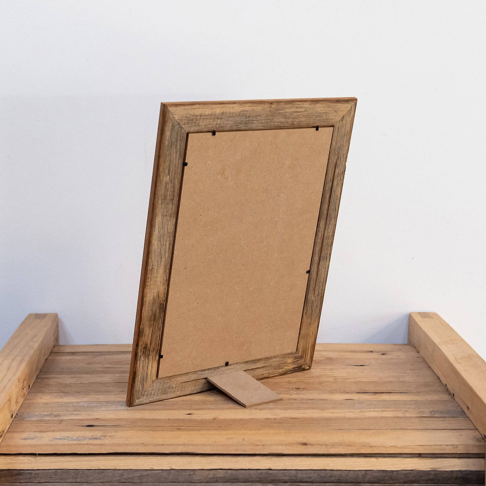 Photo of back of 8 x 12 picture frame made form recycled timber, standing on table. 