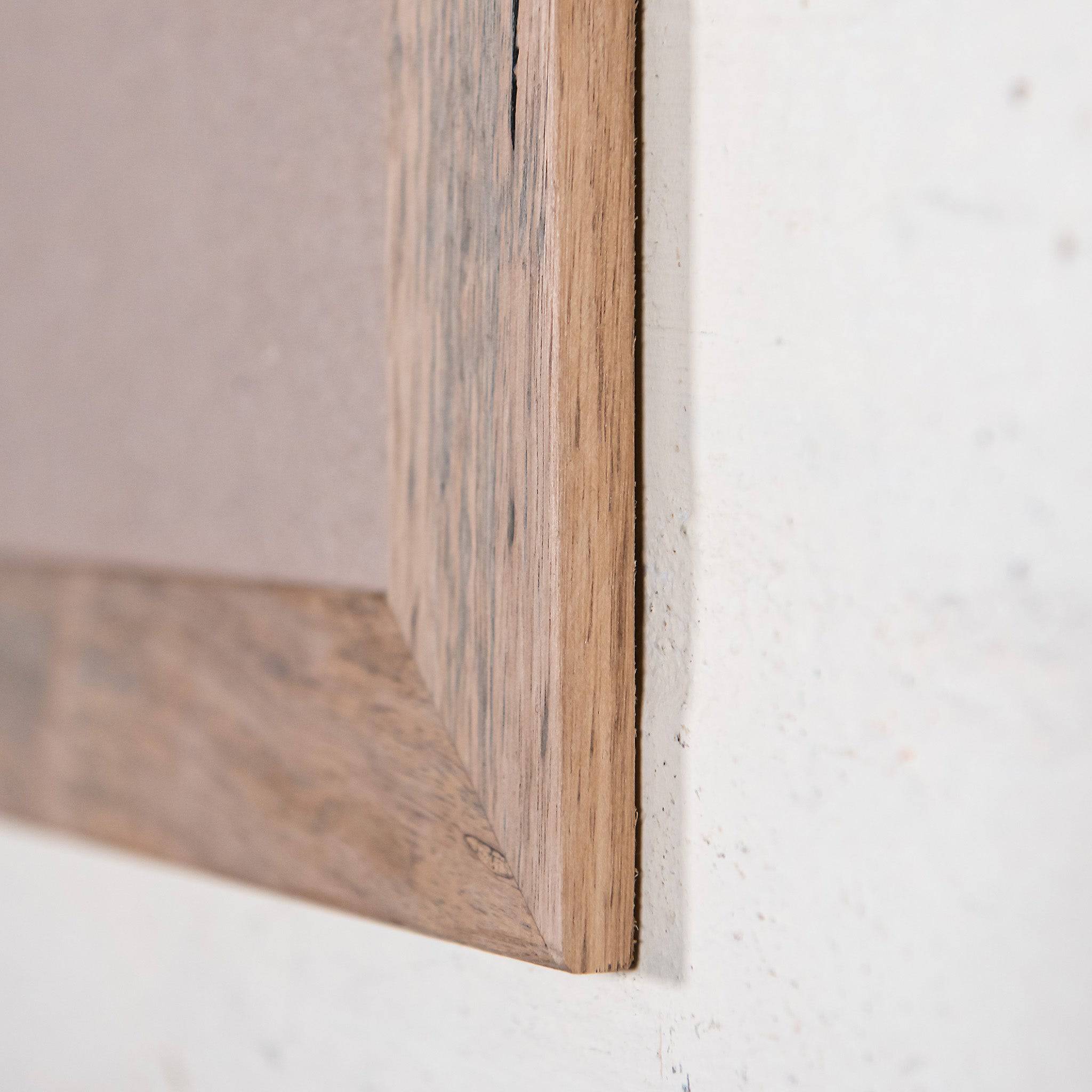 Close up of corner of natural timber photo frame with nail holes