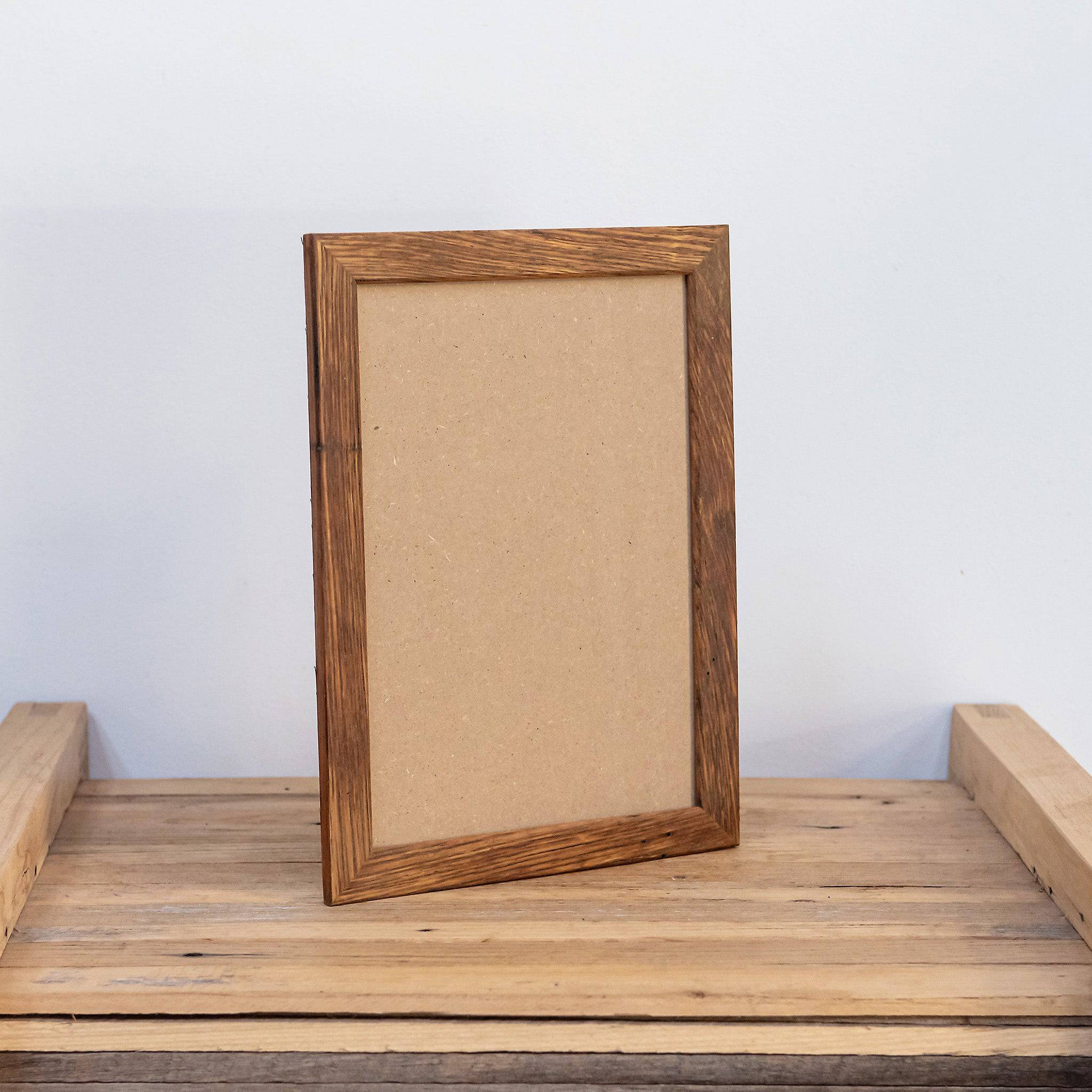 Thin, slim eco friendly wooden photo frame standing on table. Made for 8 x 12 size photo. 