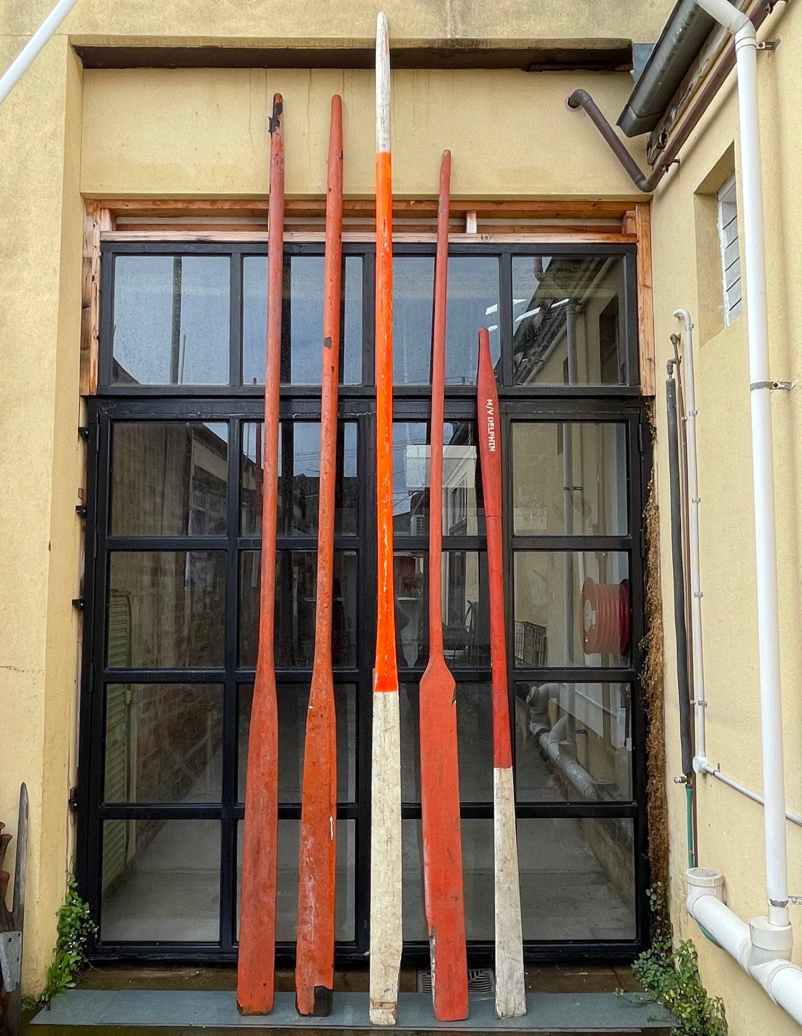 Vintage red, orange and white boat oars from life vessels. 