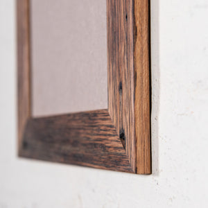 custom made photo frames. Medium brown photo frame, side on photo. Thin timber frame. 